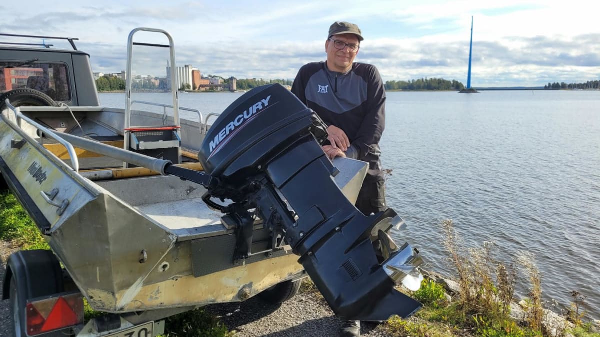 Vaasalaisveneilijä Antti Stig nojailee Palosaaren rannassa trailerin päällä olevaan perämoottoriveneeseensä