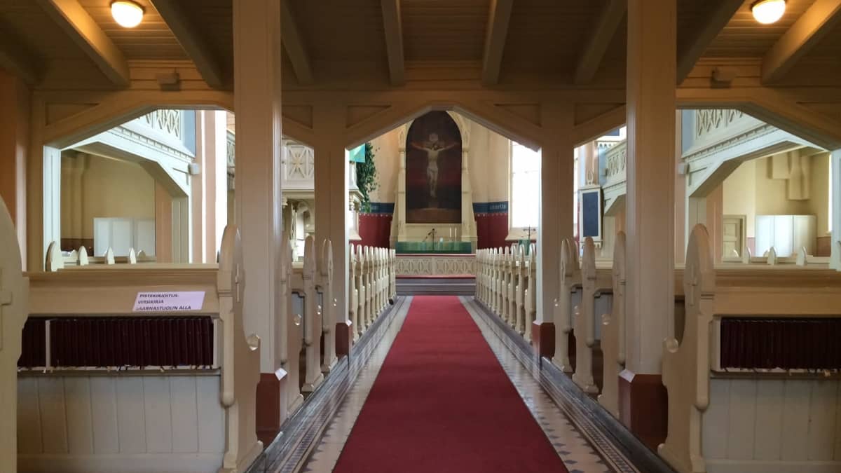 Kirkon käytävällä on punainen matto, joka johtaa alttarille.