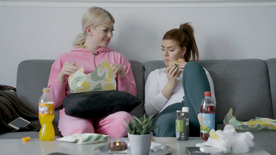 Jade ja Erica Nyström syövät pikaruokaa sohvalla.