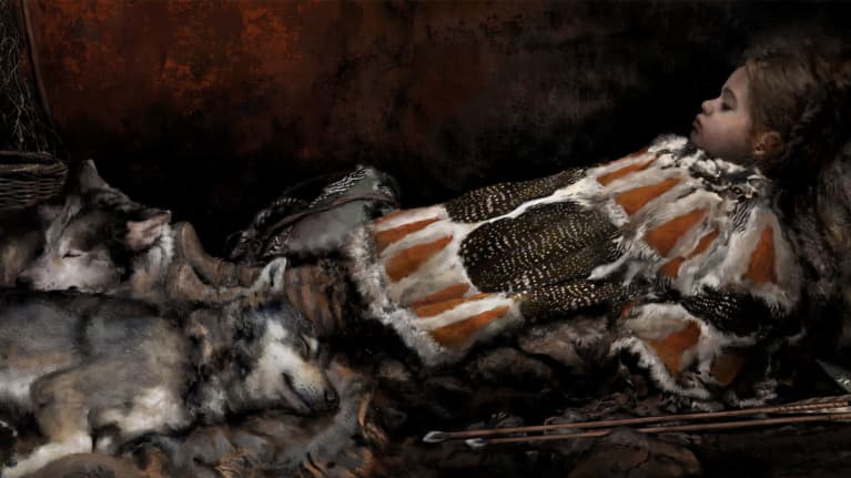 Lapsi makaa kuvassa oikealla, hän nojaa itseään puolimakaavassa asennossa. Lapsi on puettu oranssinkirjavaan turkikseen. Lapsen jalkopäässä makaa kaksi sutta.