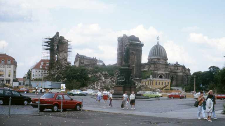 Frauenkirchen pommitettu kirkkorakennus. Kadulla ajaa autoja ja kävelee ihmisiä.