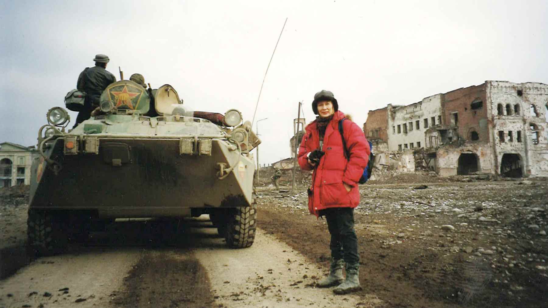 Toimittaja Outi Parikka panssariajoneuvon vierellä raunioituneessa Groznissa.