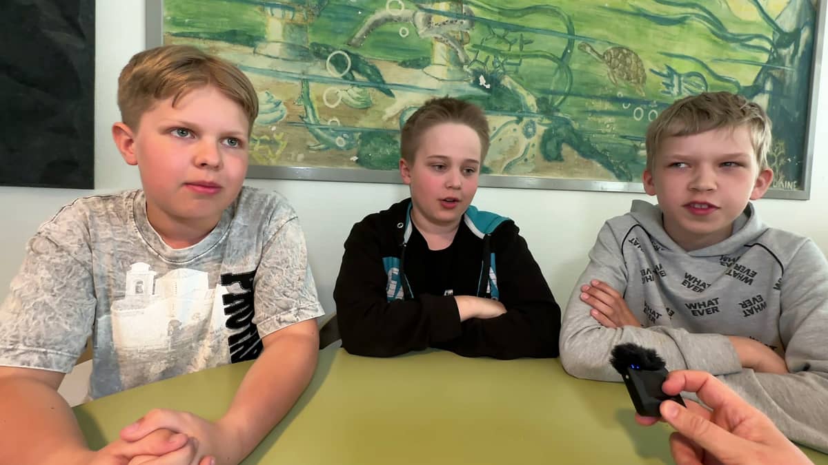 Kolme koulupoikaa istumassa Tervakoksen koulun ruokalassa.