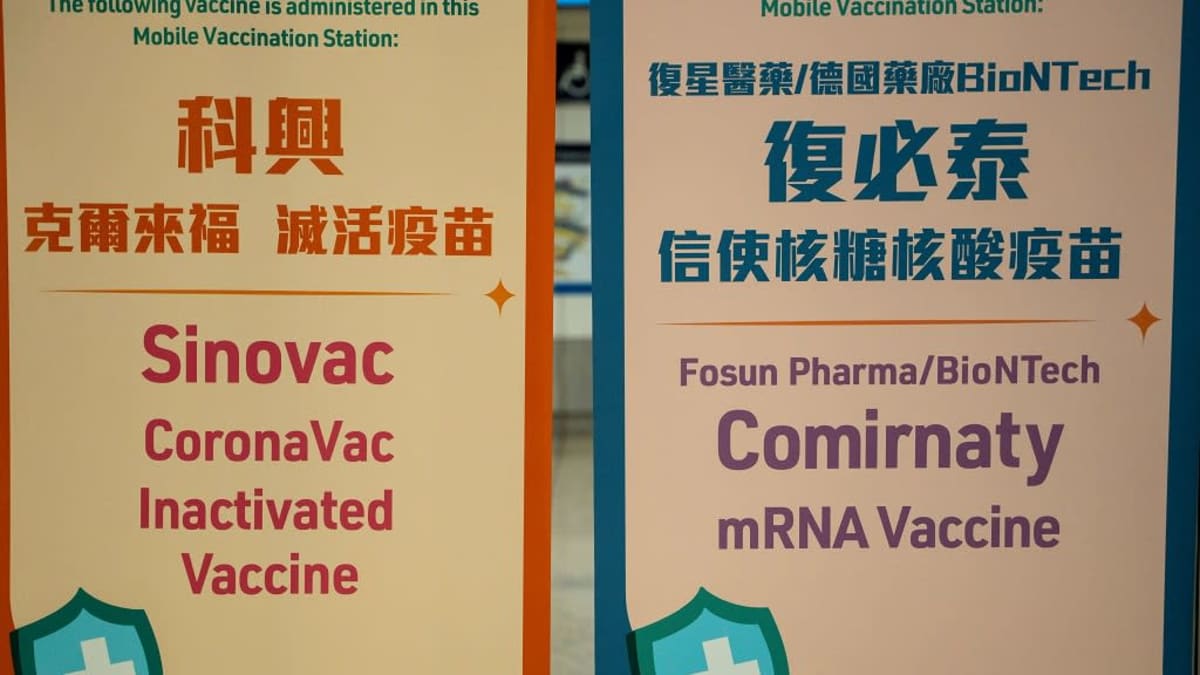 Hongkongilaisen rokotusaseman kaksi kiinan- ja englanninkielistä kylttiä kahdesta eri koronarokotteesta. 