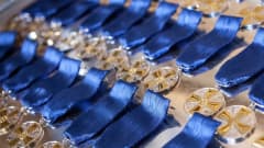 Massor av glittrande medaljer i flera rader med blå medaljband