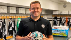 Mustassa pikeepaidassa jalkapalloa kaksin käsin rintansa edessä pitävä toimitusjohtaja Janne Kytölä hymyilee kameralle. Taustalla näkyy Tepsin pukukoppi ja pelaajien paitoja, nappulakenkiä ja huoltovälineitä.