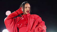 Rihanna punaisessa esiintymisasussa ja raskausvatsa näkyvillä.