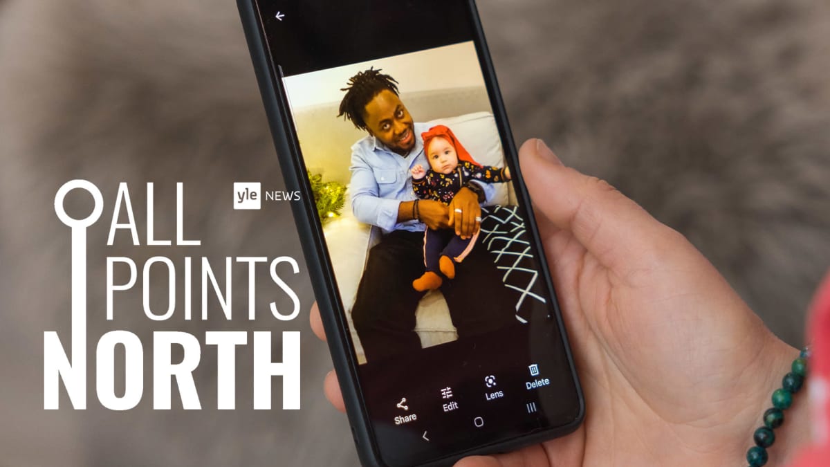 Isän ja vauvaikäisen lapsen kuva kännykän ruudulla varustettuna All Points North logolla.