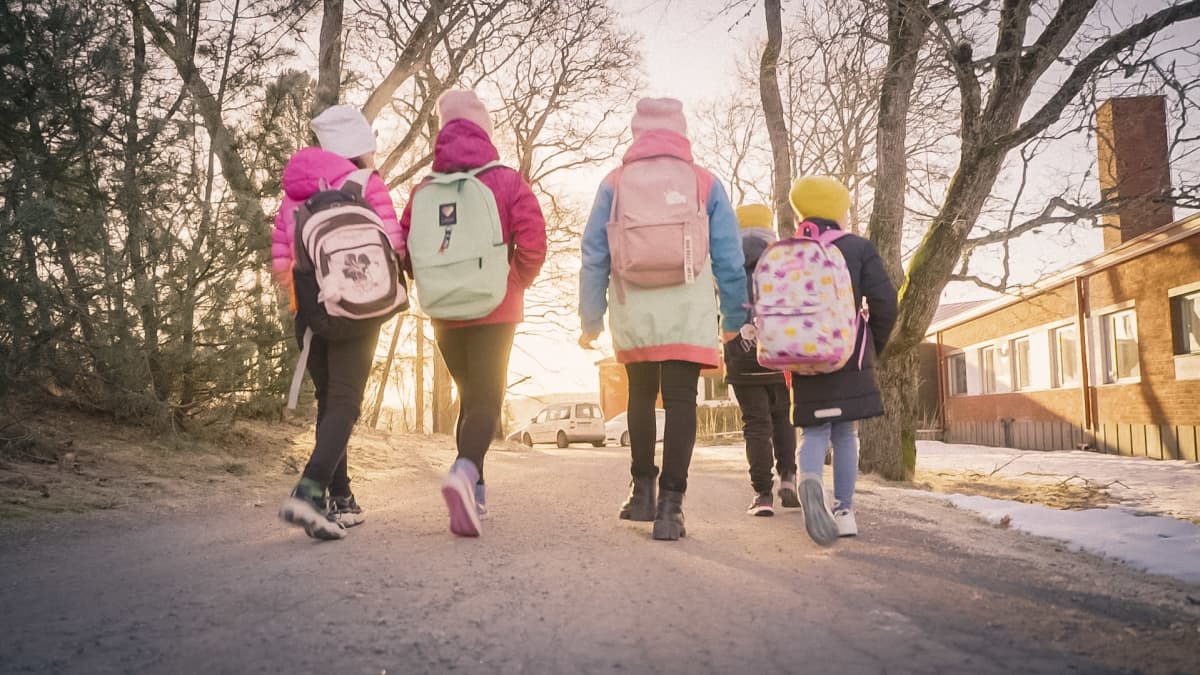 Viisi lasta koulureput selissään kävelee kohti auringonnousua.