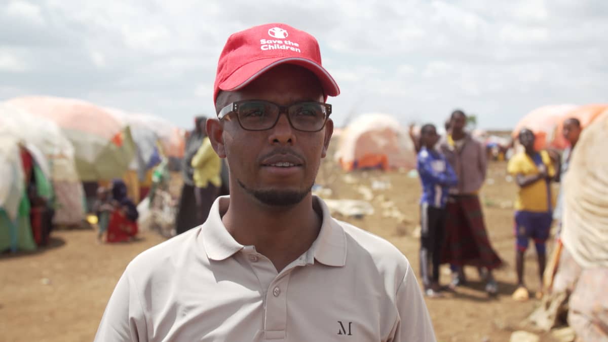 Pelastakaa lasten viestintäpäällikkö Mowlid Modan punainen lippis päässään pakolaisten telttaleirissä Somaliassa. 
