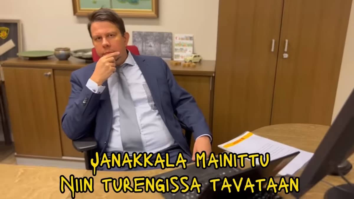 Janakkalan kunnanjohtaja Reijo Siltala istuu työhuoneessaan Rapfaijan musiikkivideolla. 