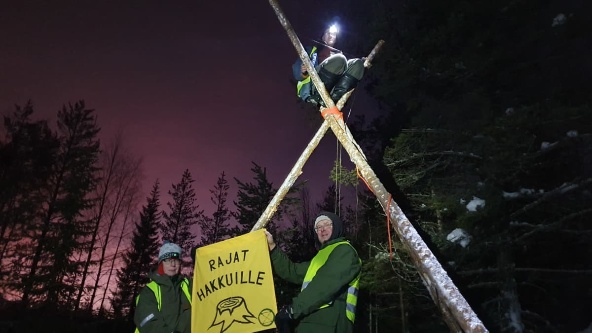 Mielenosoittajia Aalistunturilla kyltin kanssa.