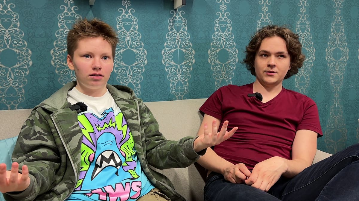 Kaksi nuorta miestä istuu sohvalla.