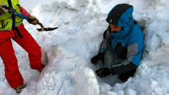 Vapaaehtoinen nousee ulos lumiluolasta pelastusharjoituksessa Levillä.