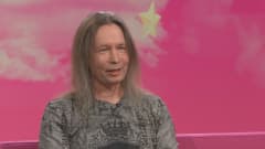 Stratovarius-yhtyeen keulahahmo Timo Kotipelto Puoli seitsemän -ohjelman studiossa istumassa pinkillä sohvalla. 