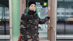 Yrittäjä Laura Johansson seisoo Kebab- ja hampurilaisravintolansa etuovella.