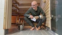 Toimittaja Jarno Kajova istuu saunan alapallilla ja katsoo kameraan.