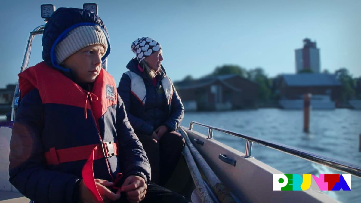 Poika ja äiti istuvat veneessä. Takana näkyy saari jolla kohoaa majakka.