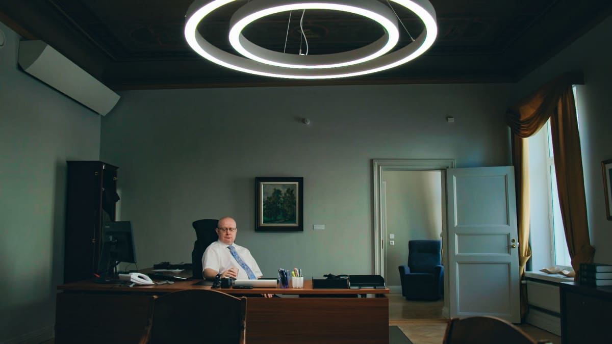 Työministeri Jari Lindströmin viimeinen työpäivä, hetki ennen seremonioita. Lindström istuu työpöytänsä takana.