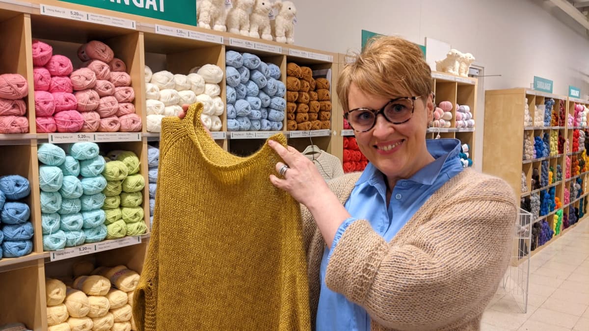 Helsingin Oulunkylässä sijaitsevan Lankamaailman myymäläpäällikkö Katariina Tiainen esittelee raikkaan väristä villapaitaa.