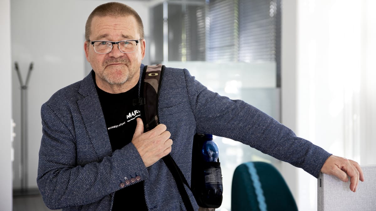 Jukka Linberg nojaa hymyillen toimiston sermiin.