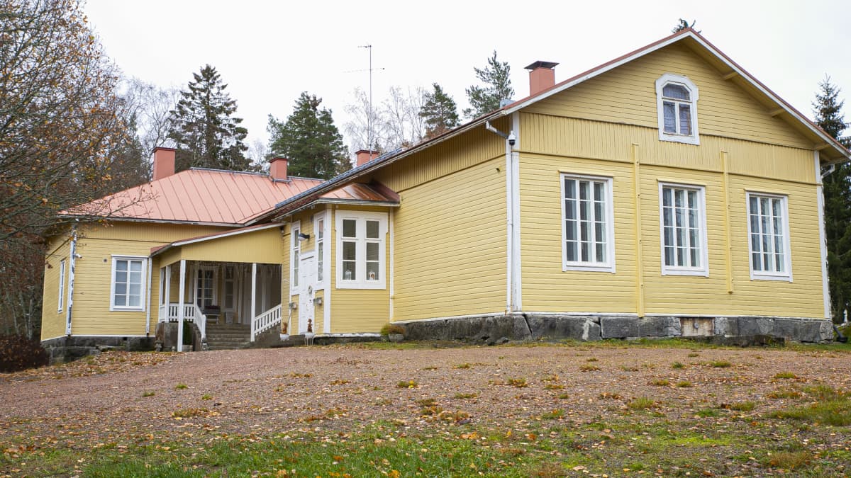 Keltainen asumiskäyttöön remontoitu koulurakennus.