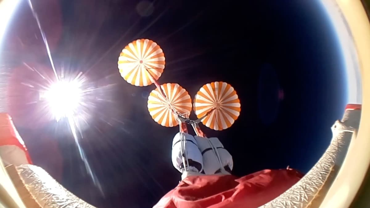Kolme laskuvarjoa ja Aurinko kuvassa, joka on otettu hyötykuormalavetista ylöspäin laskeutumisen aikana.