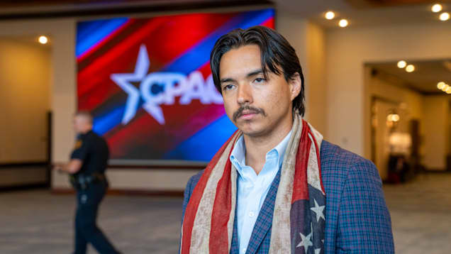 Nuori mies seisoo sisällä.