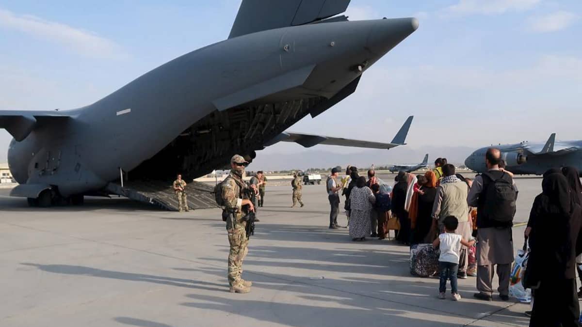 Puolustusvoimien suojausjoukon sotilaita ja evakuoitavia ihmisiä Kabulin lentokentän alueella Afganistanissa.
