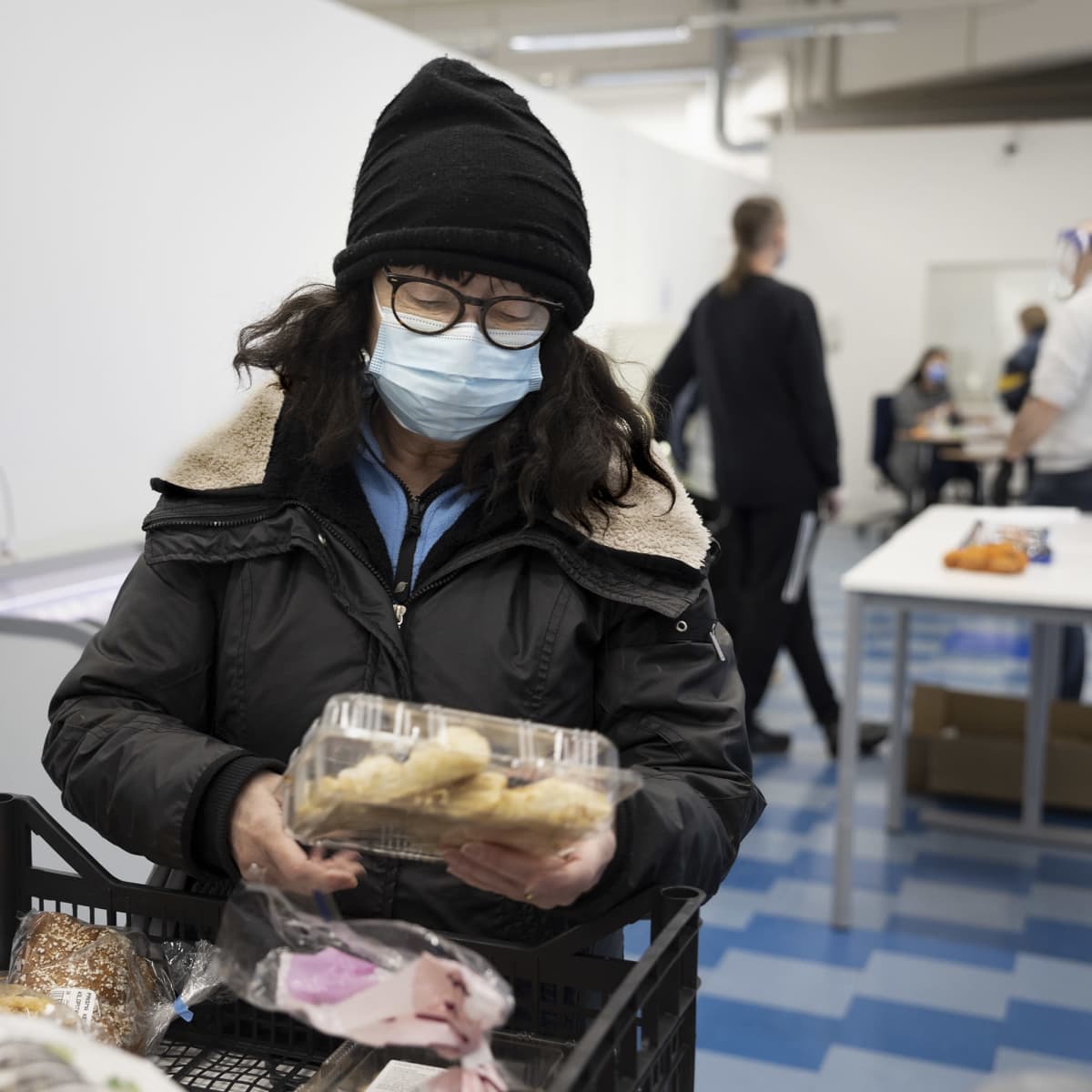 Jyväskyläläinen Sirkku Duruji tutkii ruoka-avussa tarjolla olevaa leivonnaispakkausta.