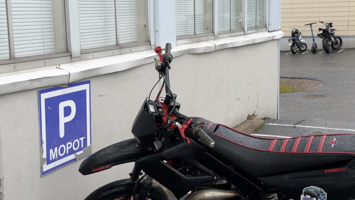 Mopoja ja sähköskootteri parkissa.