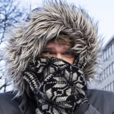 Suotamo huppupäässä, lapaset peittää kasvot, vain silmät näkyvät.