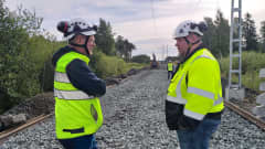 Kaksi miestä seuraa junaradan remonttia