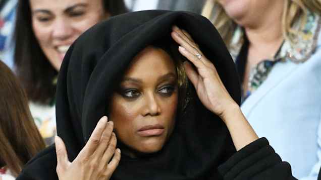 Tyra Banks istuu katsomossa ja pitelee kiinni hupustaan.