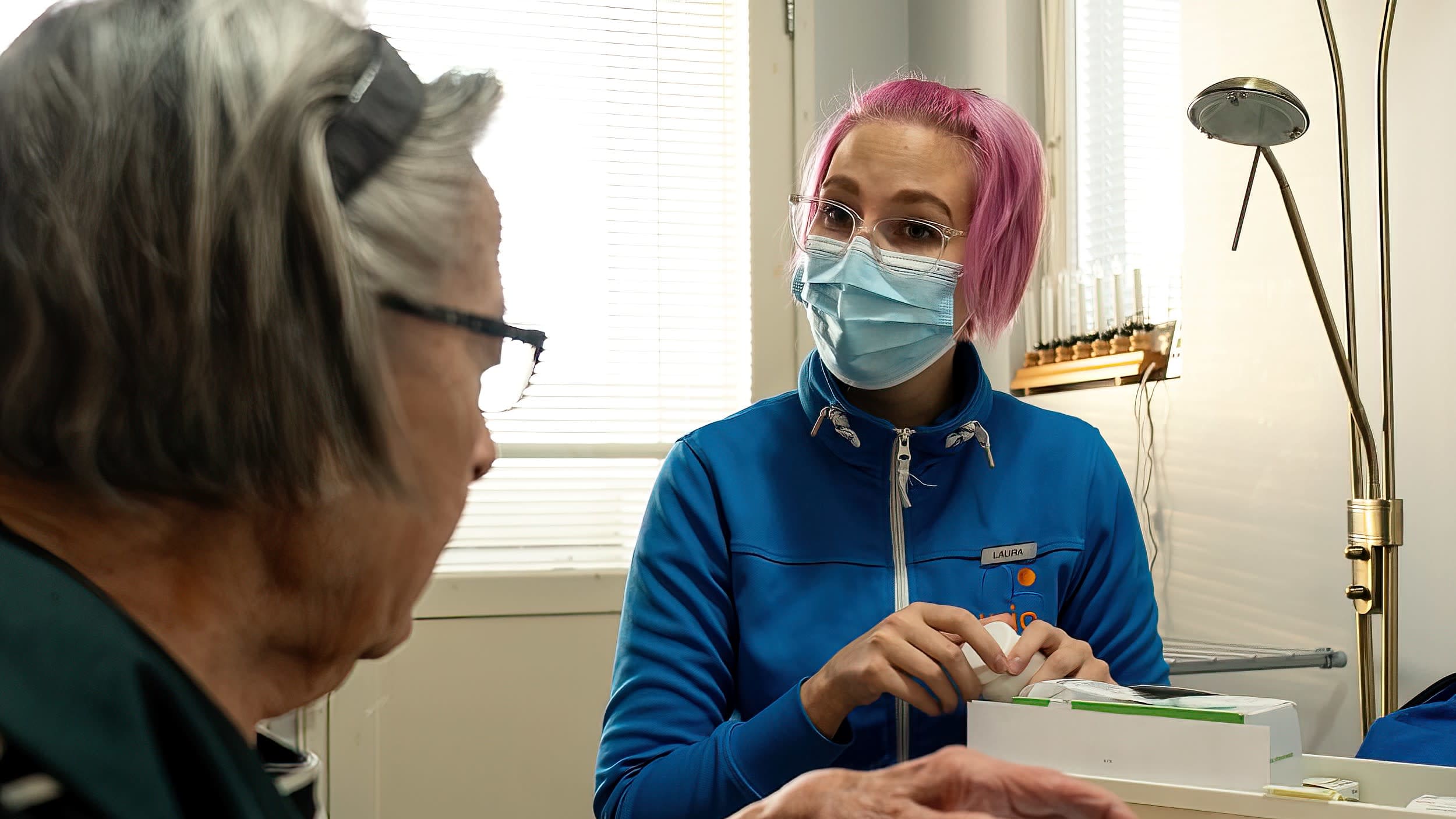 Aurio Hoivan lähihoitaja Laura Hahl ottaa lääkkeitä purkista kotihoitoasiakkaansa luona.