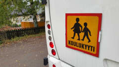 Koulukuljetuksesta kertova koulukyyti-kyltti linja-auton perässä. 