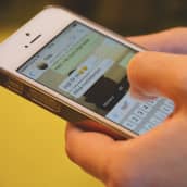 En närbild av händer som skriver meddelandet vgd på appen whatsapp på en smarttelefon.