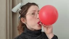 Toimittaja Anna Polo puhaltaa ilmapalloa