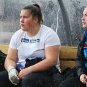 Silja Kosonen ja Krista Tervo istuvat sateensuojassa Paavo Nurmen kisoissa. 