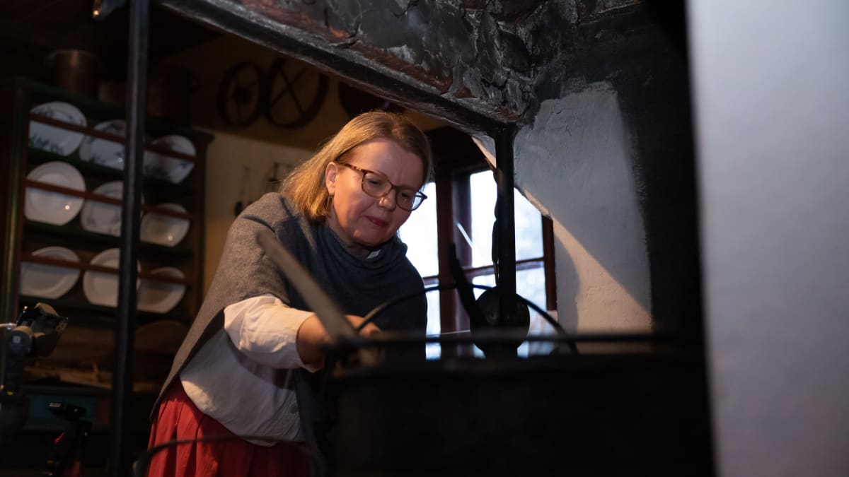 Nainen kohentaa tulta