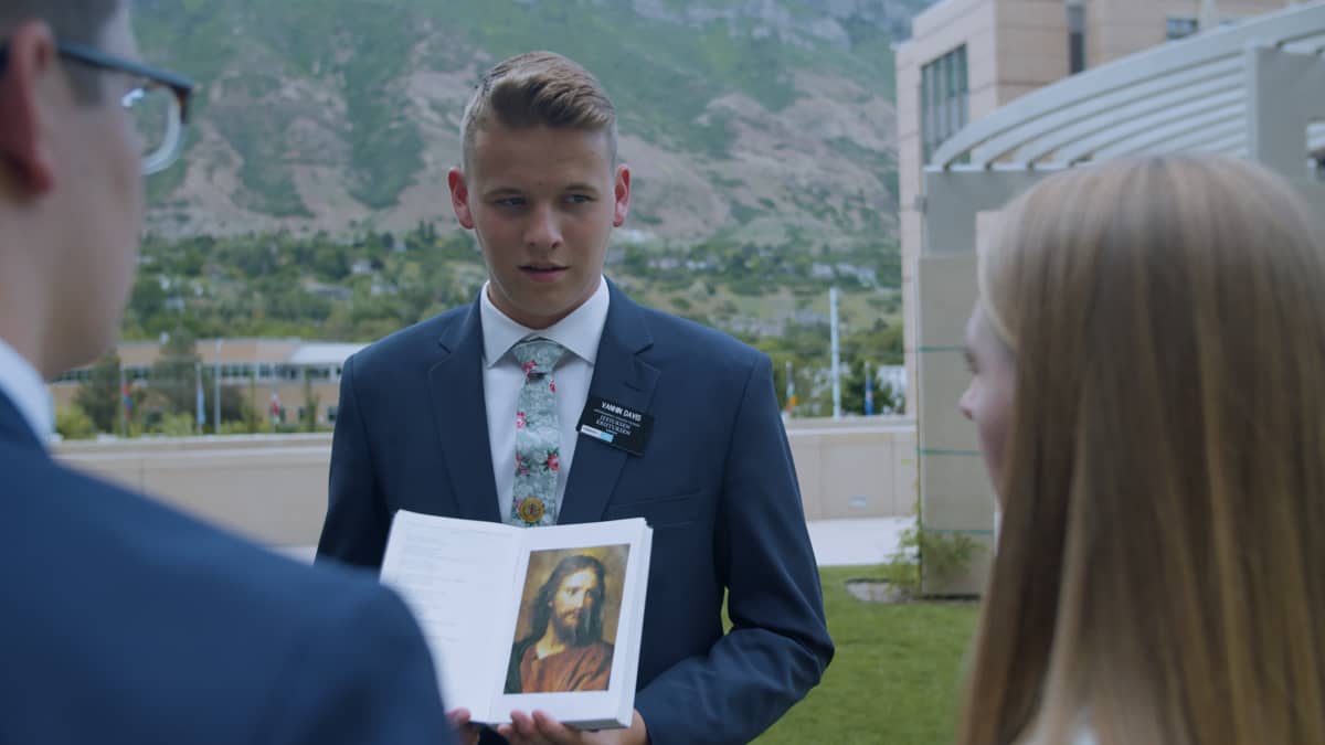 Mormoni näyttää Jeeuksen kuvaa kahdelle muulle ihmiselle.