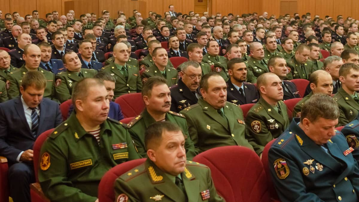 Iso joukko Venäjän kansalliskaartin upseereja istuu kokoussalissa, useimmilla vihreä univormu. 