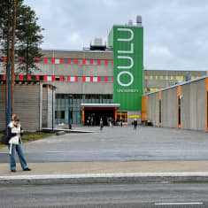 Ihmisiä liikkuu Oulun yliopiston pääoven edustalla.