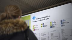 en infoskylt över Vasa Centralsjukhus med en kvinna i förgrunden