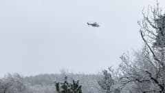 Pelastushelikopteri talvisessa maisemassa.