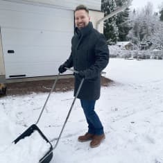 Tapio Haapanen luo lunta kotipihallaan.