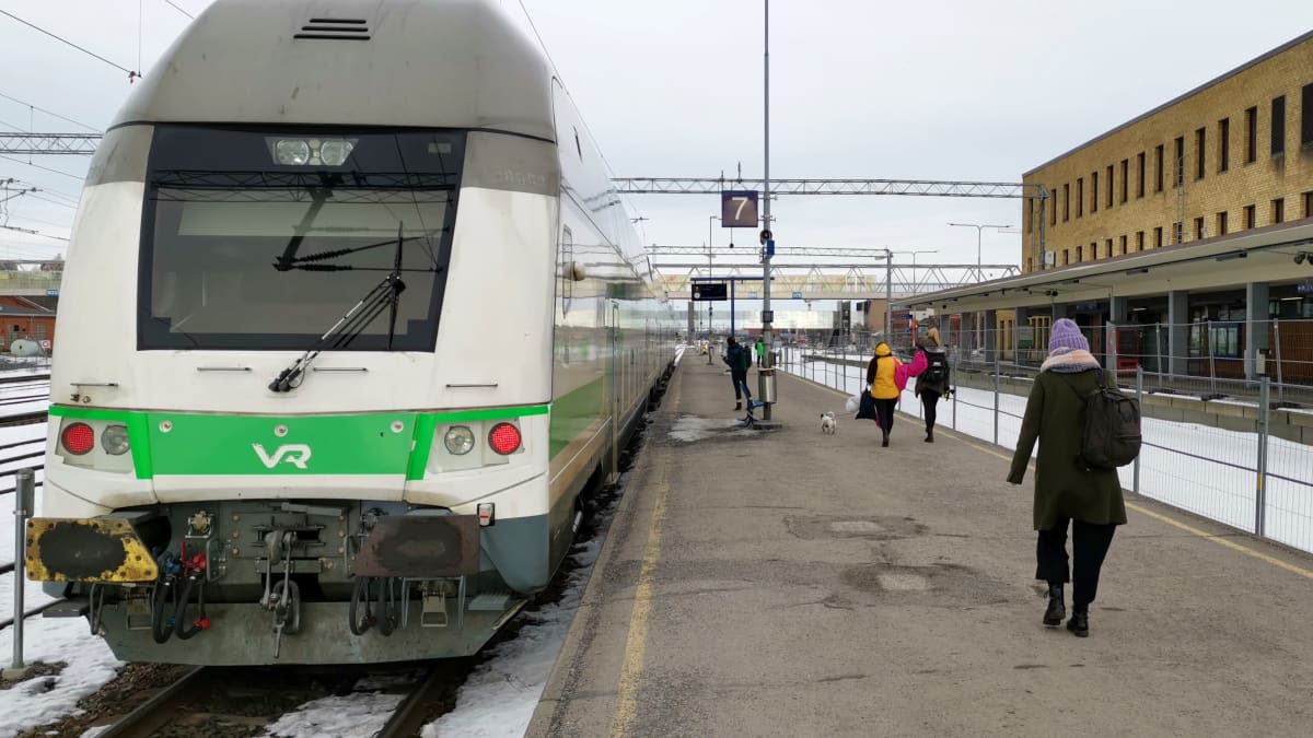 IC2-juna Turun päärautatieasemalla, ihmisiä kävelemässä asemalaiturilla, asemalaiturin vieressä työmaa-aitoja.