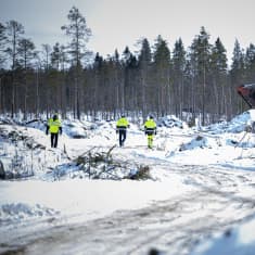 Kolme miestä kävelee Keliberin kaivostyömaalla. 