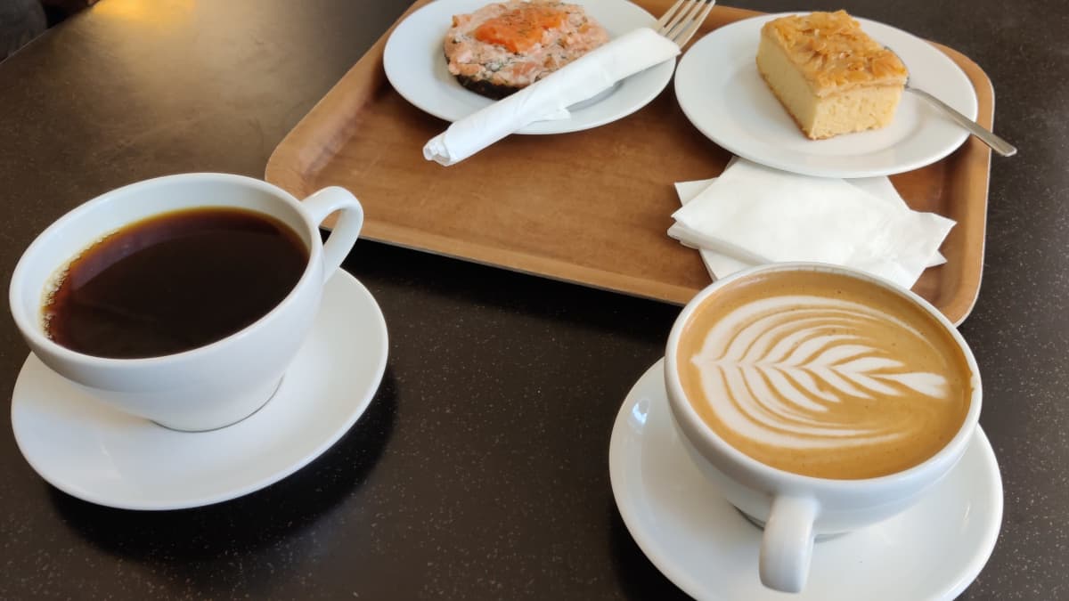 Musta kahvi ja latte kahvilan pöydällä