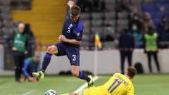Albin Granlund pomppaa ylöspäin, kun Kazakstanin Yan Vorogovskiy liukuu hänen jaloistaan pallon ohi sivurajan.